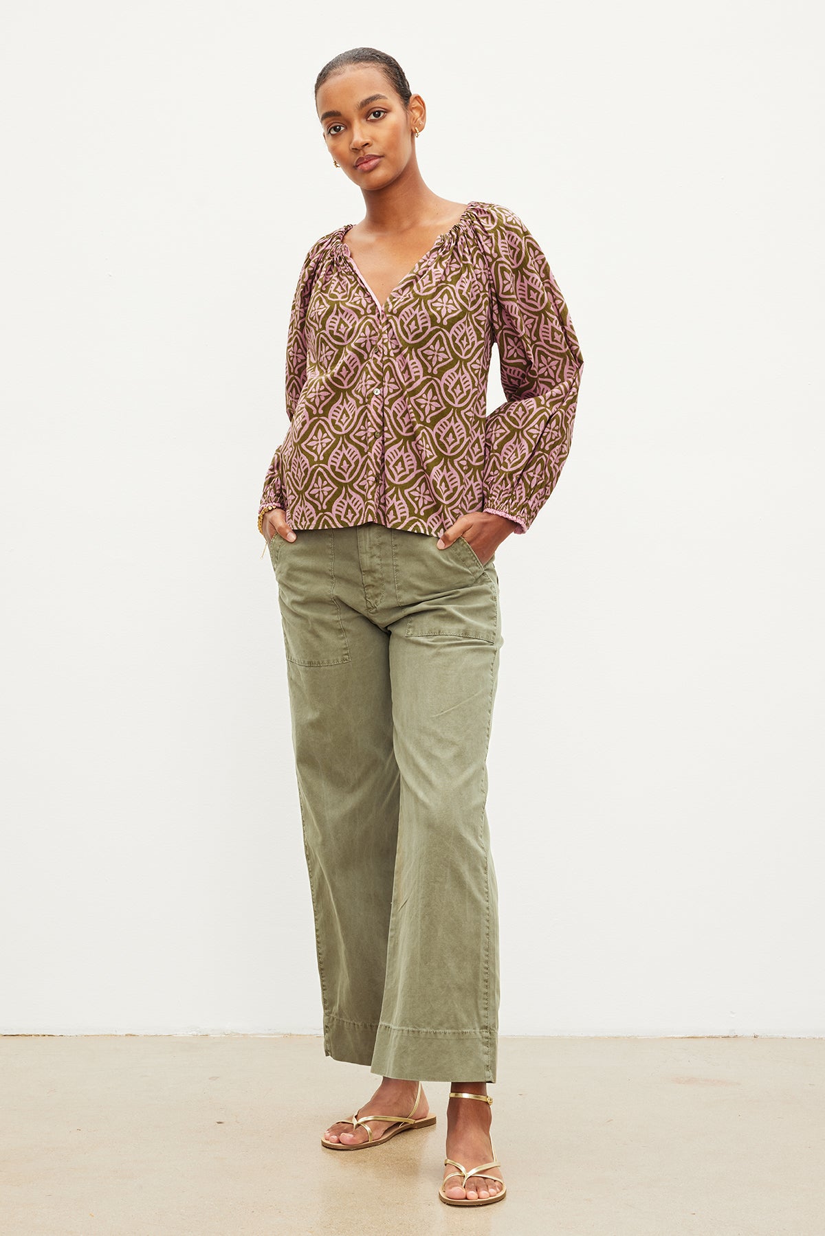 The model is wearing a MARIAN PRINTED BUTTON FRONT TOP by Velvet by Graham & Spencer. The top features a buttoned front, giving it a stylish and versatile look. With its v-neckline, it adds-35967584436417