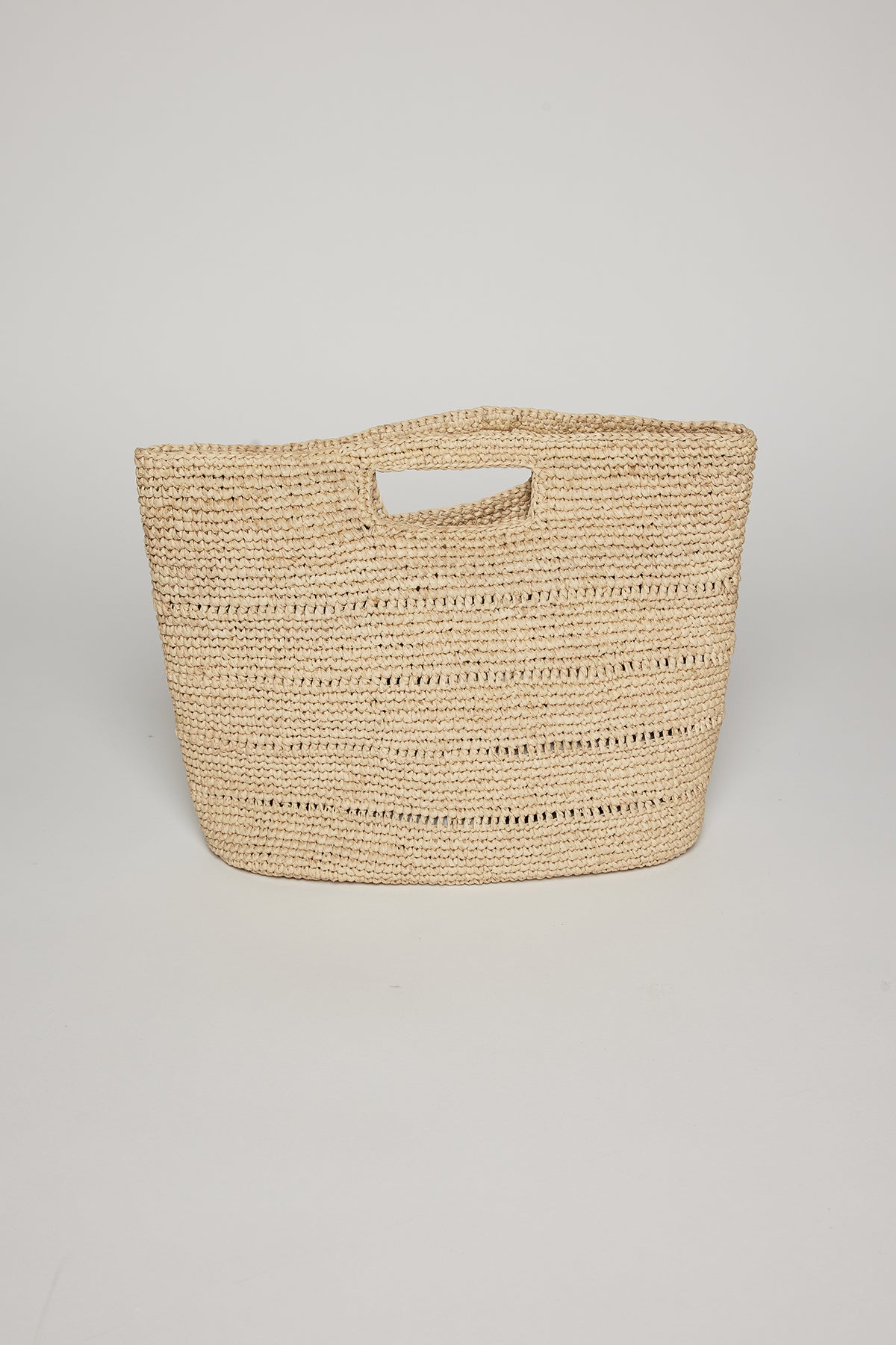   A beige raffia Naomi handheld straw bag by Velvet by Graham & Spencer with horizontal patterns, displayed against a plain white background. 