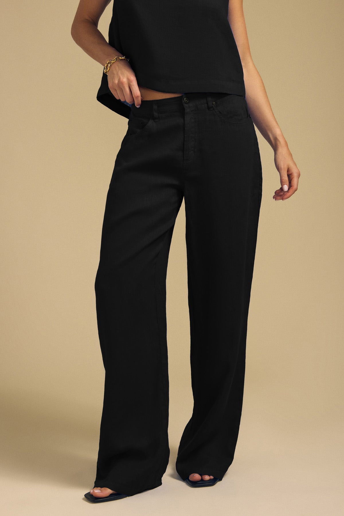 Person wearing a sleeveless black top and NATALIE LINEN PANT wide-leg linen pants with an elastic waistband.-46422215688385