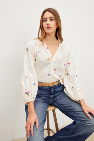 The model is wearing a white Velvet by Graham & Spencer blouse with embroidered flowers.
