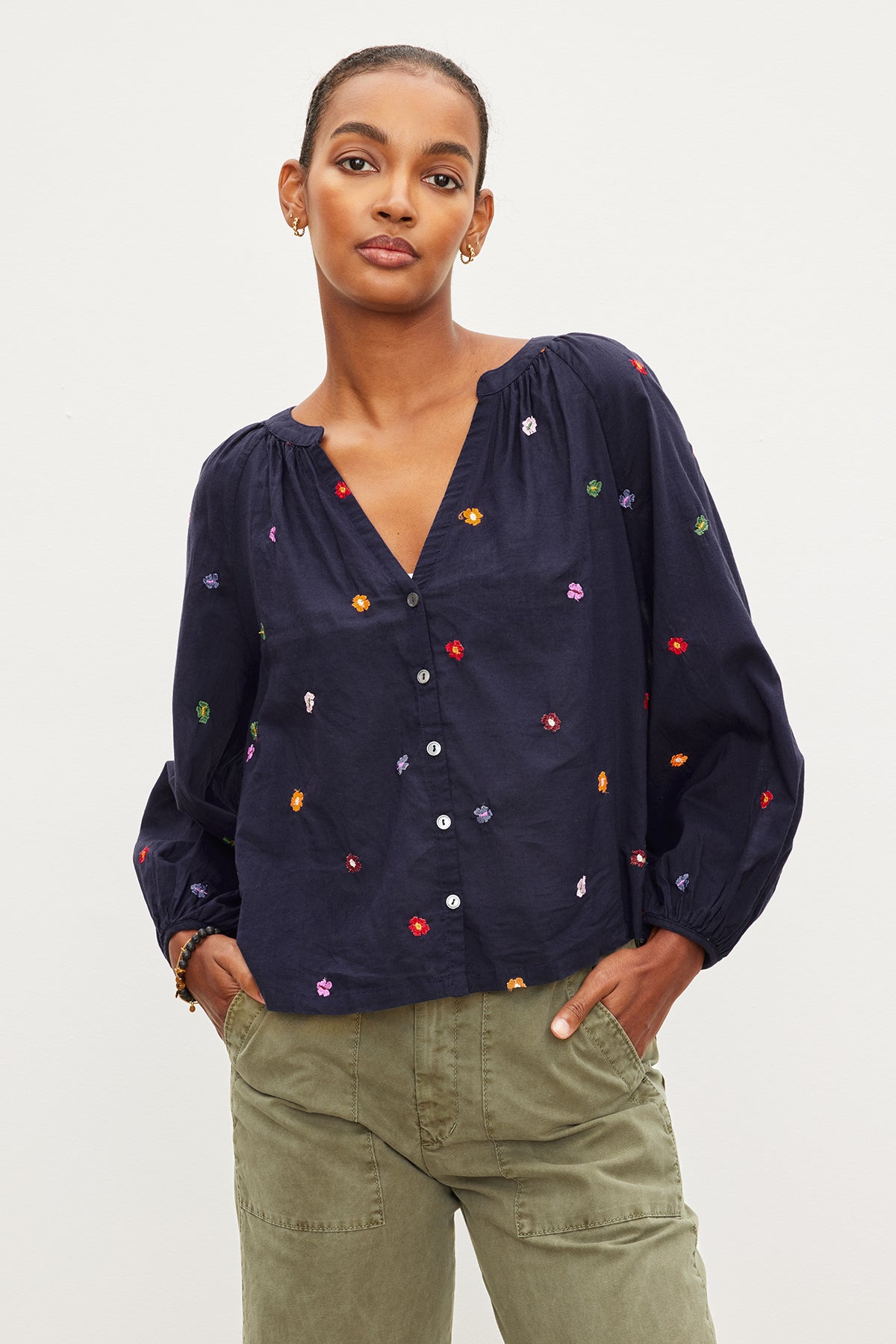   The model is wearing a Velvet by Graham & Spencer ARETHA EMBROIDERED BOHO TOP with multi - colored embroidered dots. 