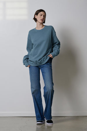 A woman wearing organic cotton blue jeans and a Velvet by Jenny Graham Abbot sweatshirt.