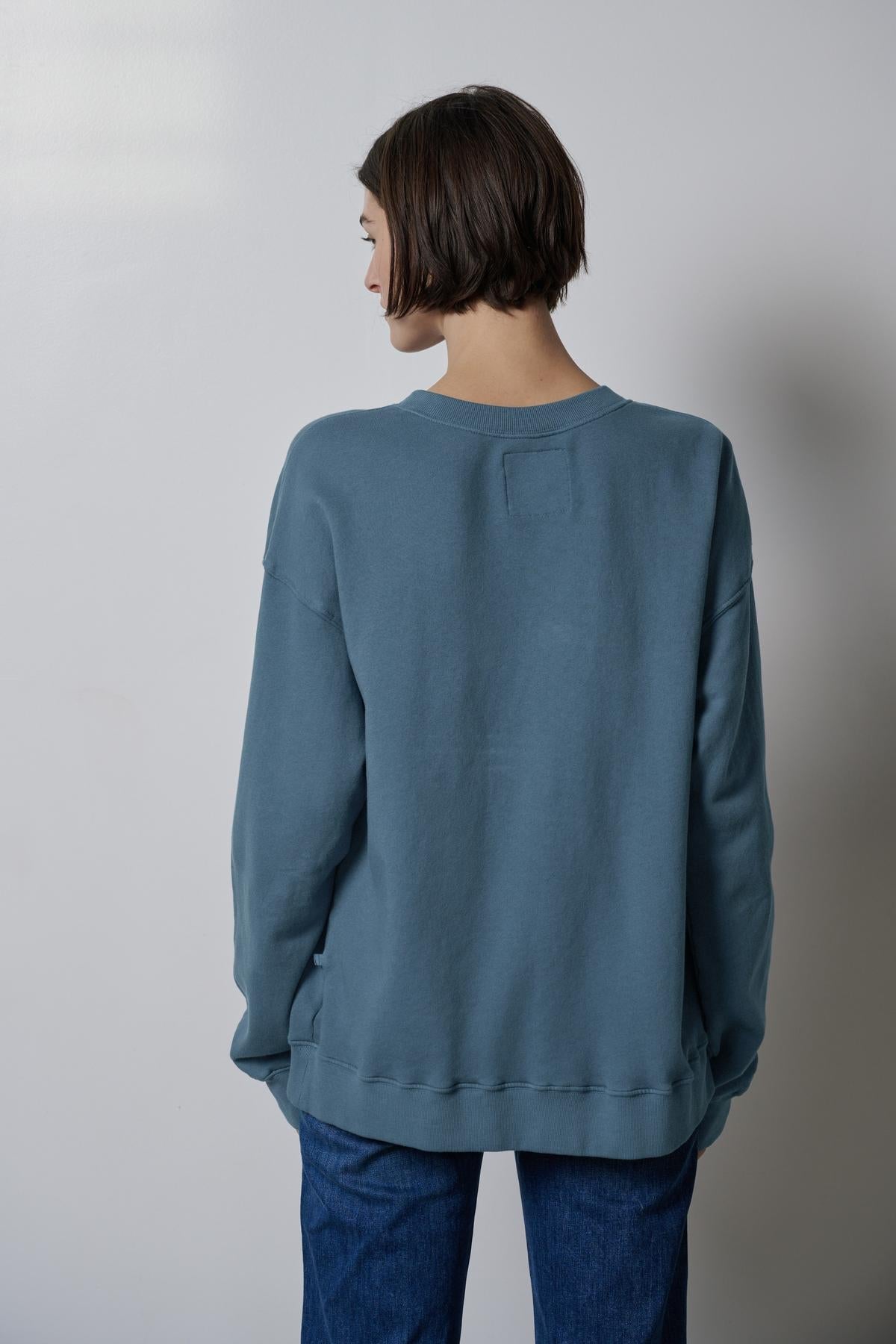 The back view of a woman wearing a slouchy Velvet by Jenny Graham ABBOT SWEATSHIRT.-36594460623041