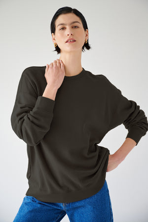 A woman rocking a slouchy black Velvet by Jenny Graham sweatshirt and jeans.