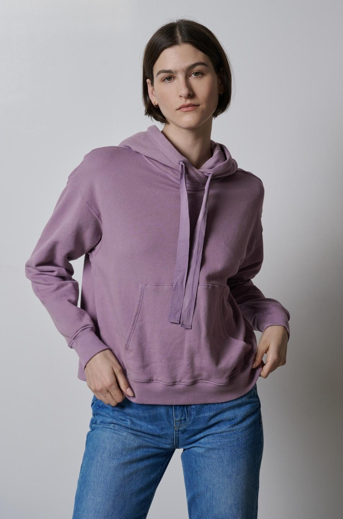   A model wearing a OJAI HOODIE by Velvet by Jenny Graham and jeans. 