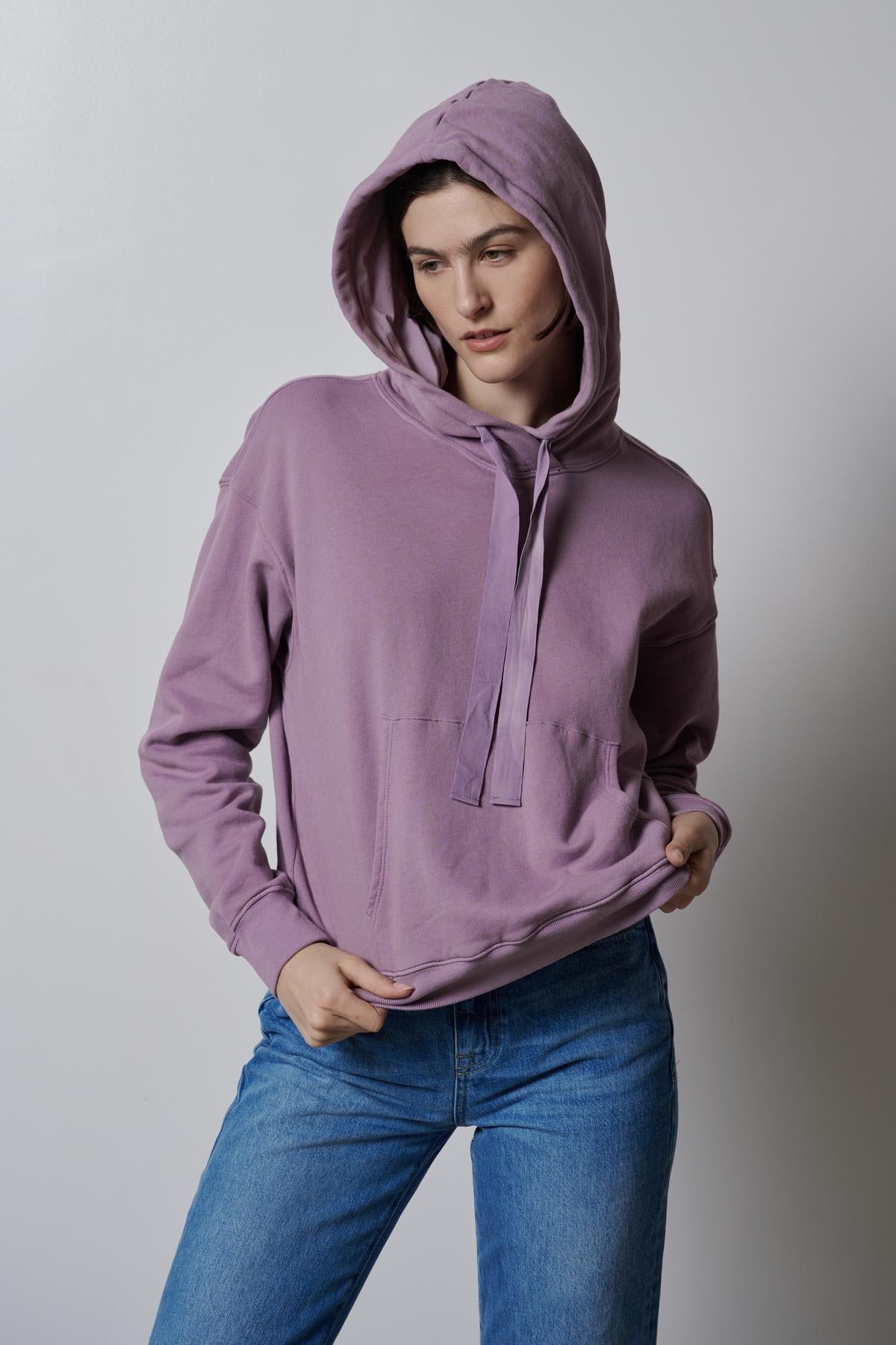   A woman wearing a OJAI HOODIE by Velvet by Jenny Graham and jeans. 