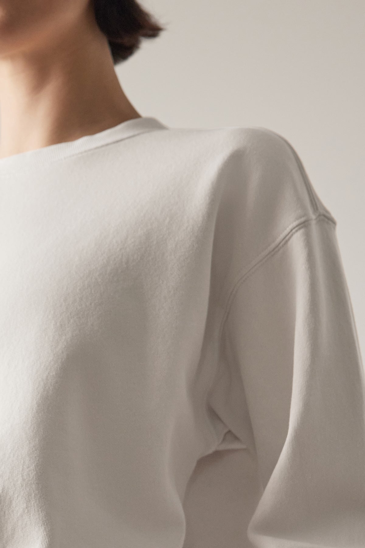   Rear view of a woman wearing a Velvet by Jenny Graham Ynez Sweatshirt made of organic cotton, focusing on the shoulder seam and soft fabric texture. 