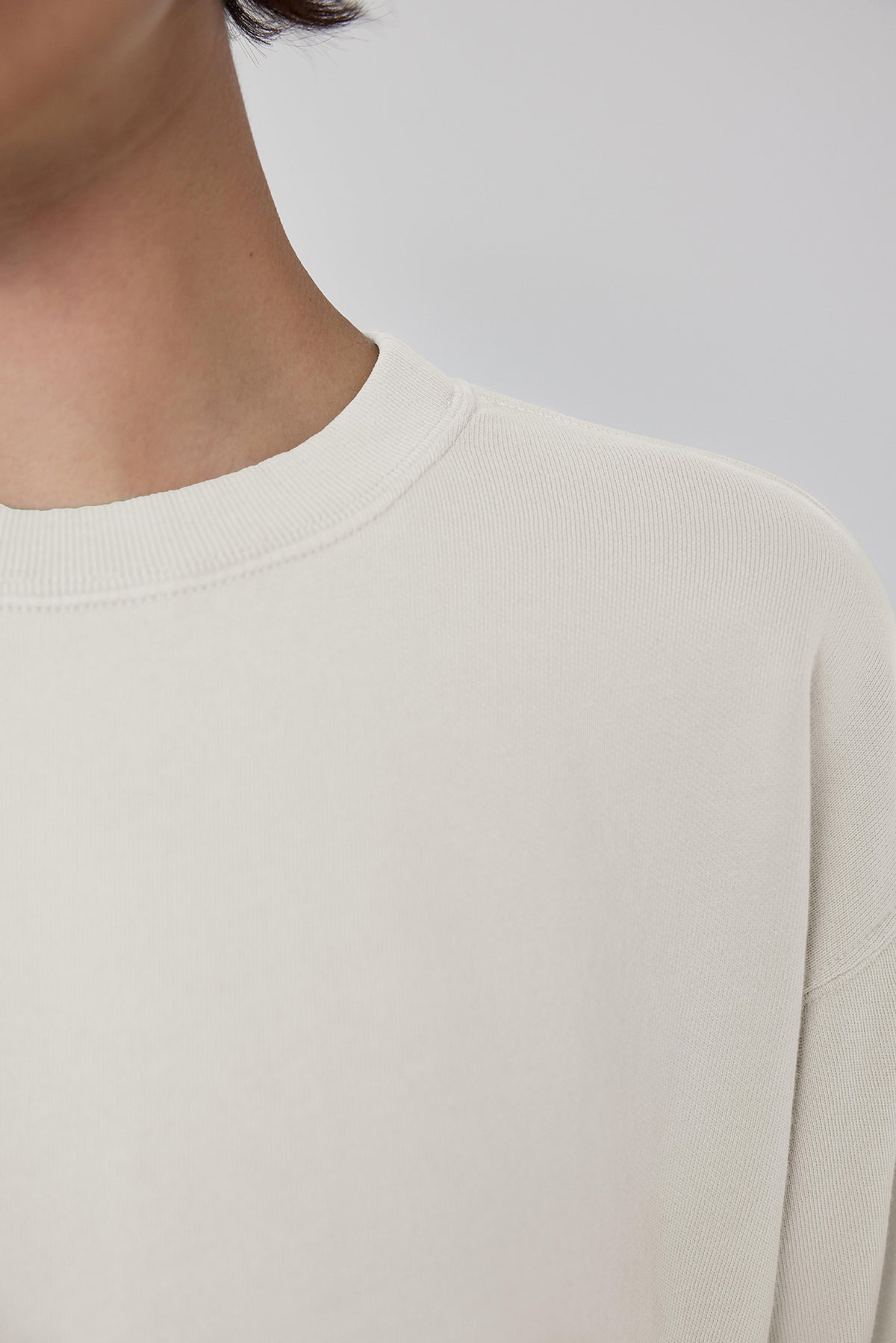   A woman wearing a white YNEZ SWEATSHIRT with a slight crop and dropped shoulder by Velvet by Jenny Graham. 