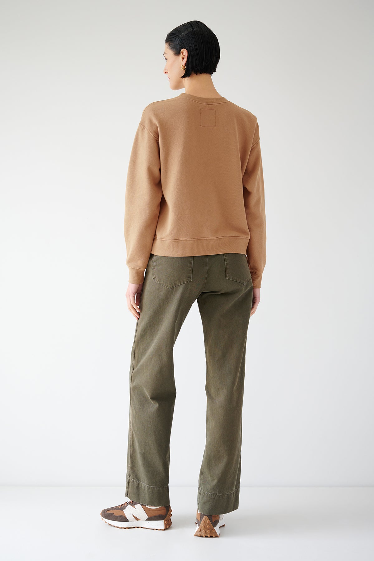 The back view of a woman wearing a Velvet by Jenny Graham YNEZ SWEATSHIRT and olive pants.-35547451064513