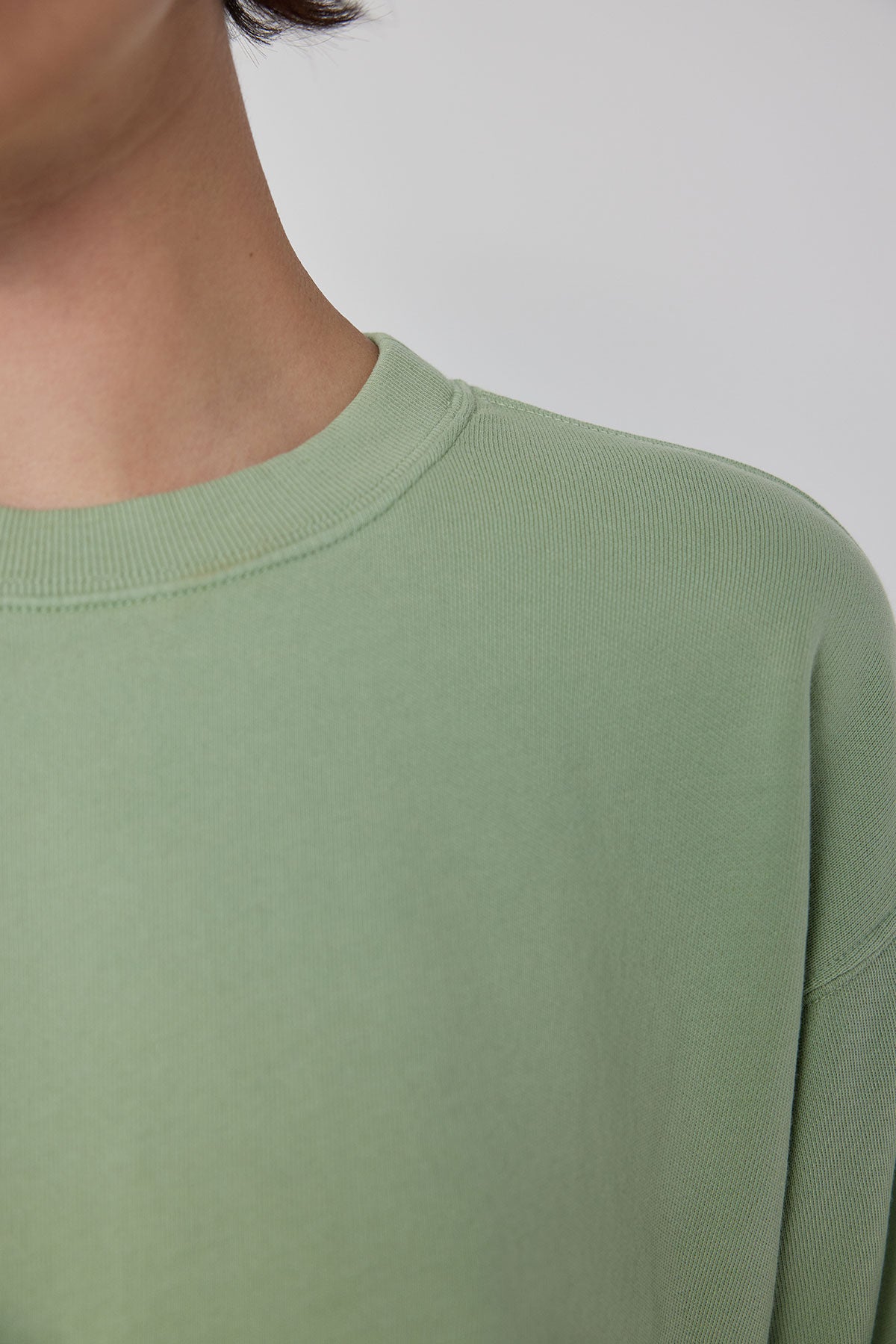 The back of a woman wearing a green Velvet by Jenny Graham YNEZ SWEATSHIRT.-36212423164097