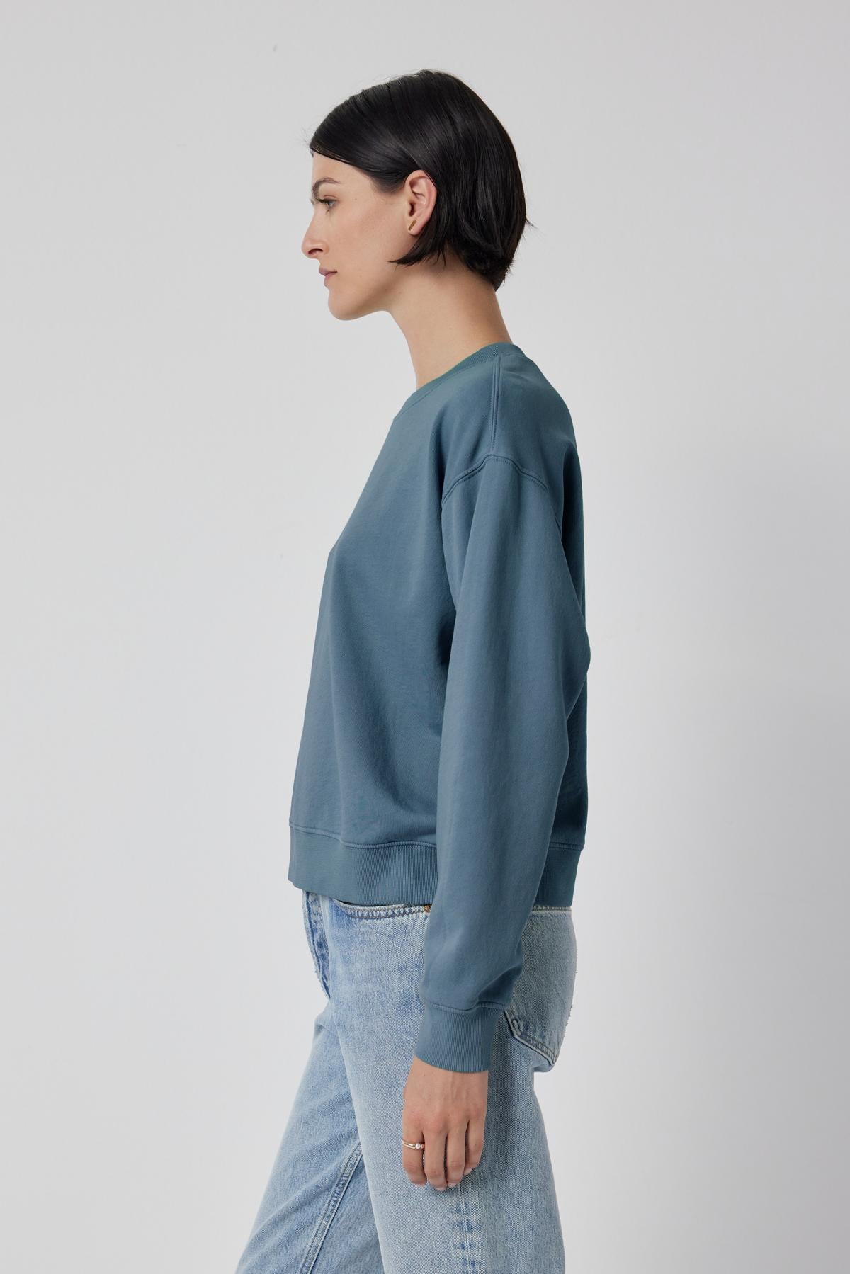 The model is wearing a dropped shoulder blue YNEZ SWEATSHIRT made of organic fleece by Velvet by Jenny Graham.-35721183723713