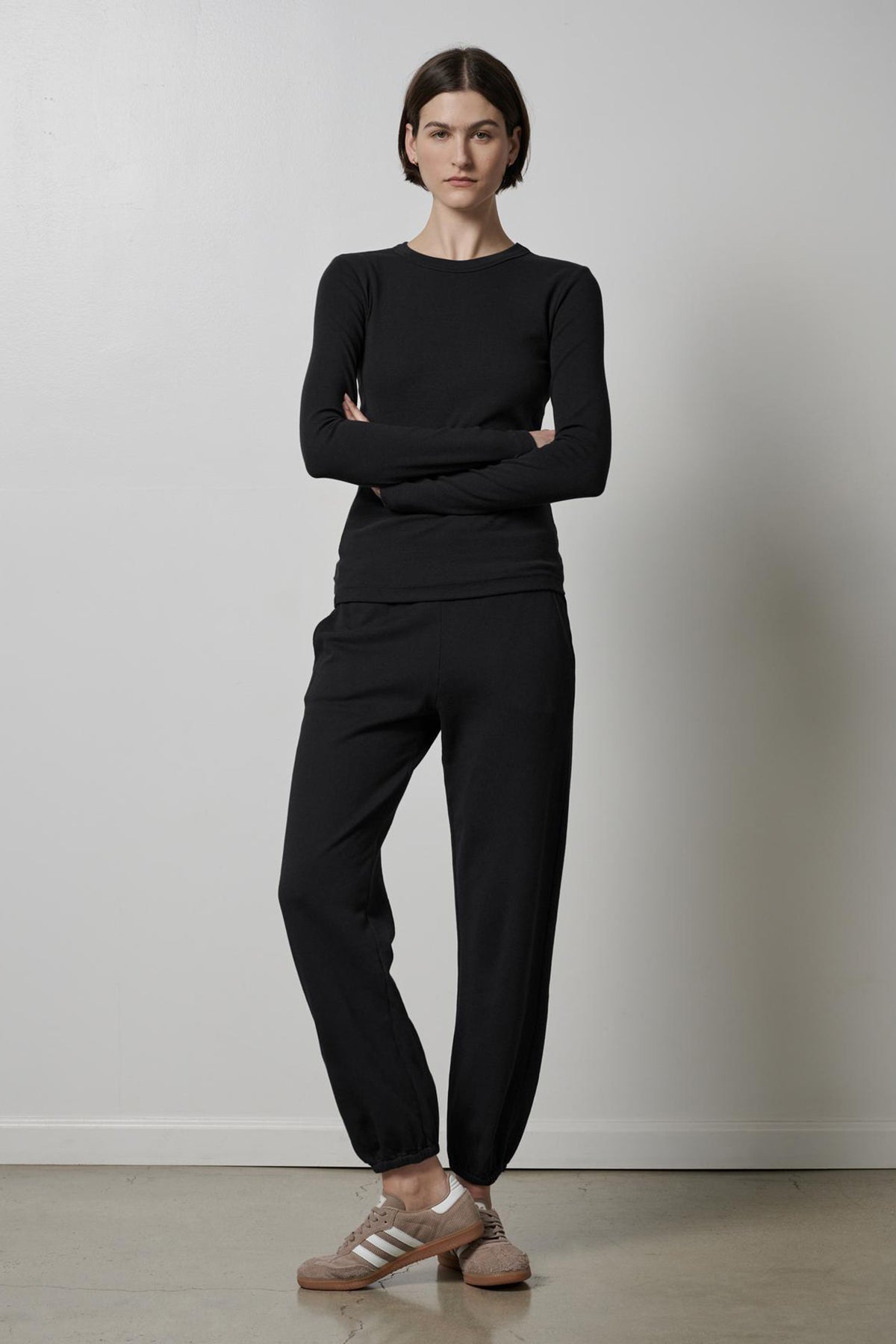   A woman wearing a black long-sleeved top and ZUMA SWEATPANT made from organic cotton. Brand Name: Velvet by Jenny Graham. 