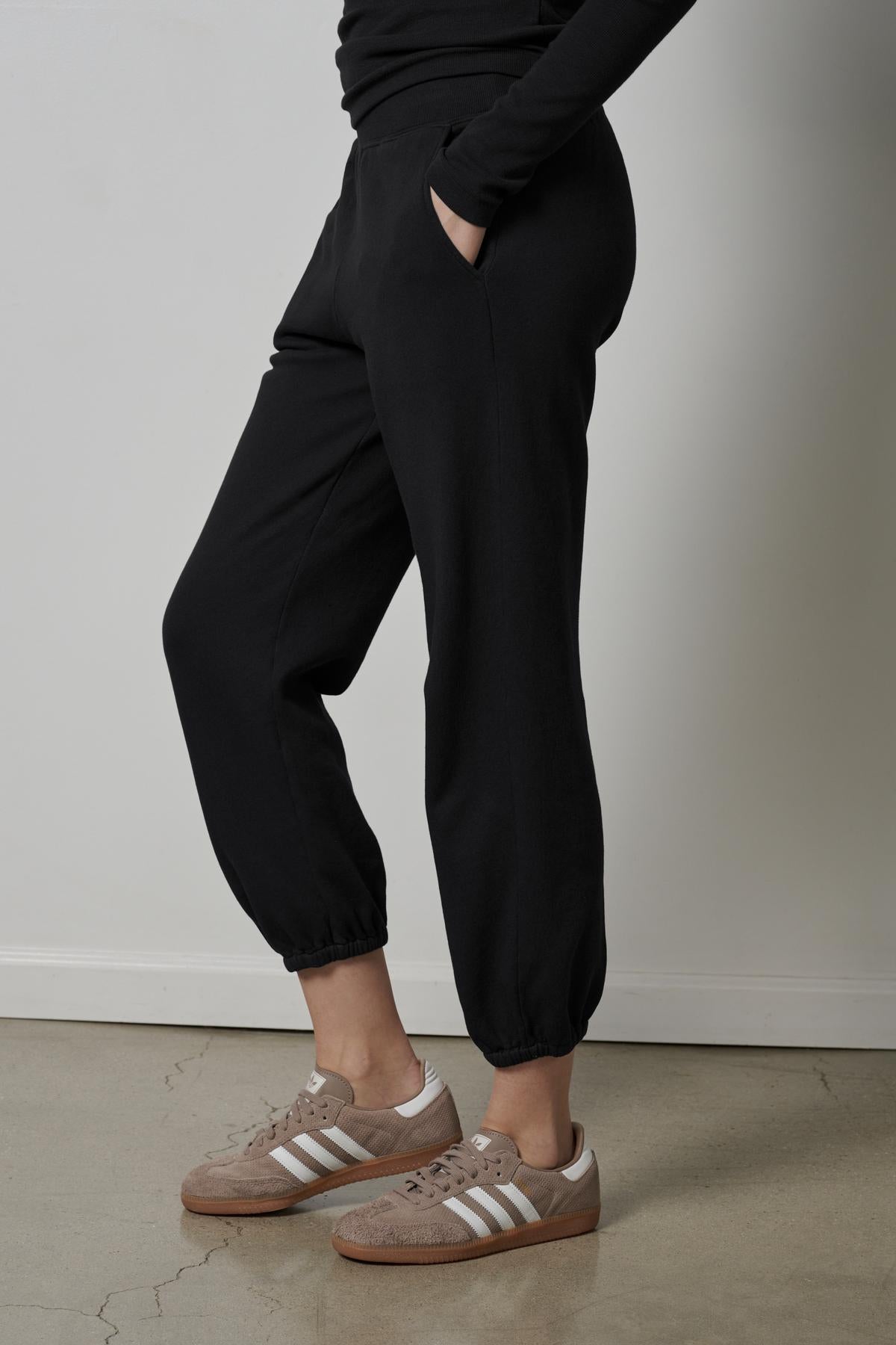   A woman wearing Velvet by Jenny Graham ZUMA sweat pants and sneakers. 