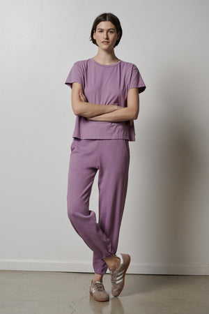 A woman wearing a lavender tee and Velvet by Jenny Graham ZUMA SWEATPANT joggers.