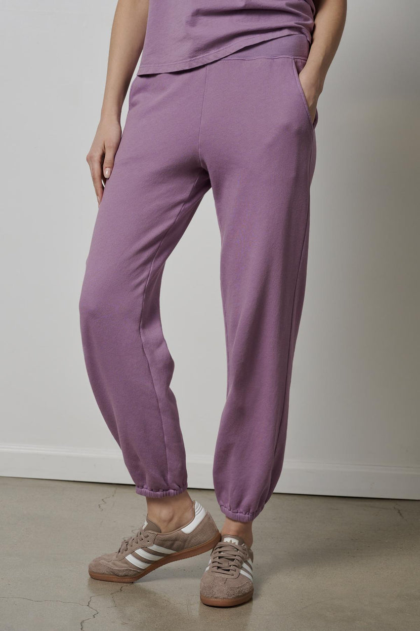 A woman wearing a ZUMA SWEATPANT by Velvet by Jenny Graham and sneakers.