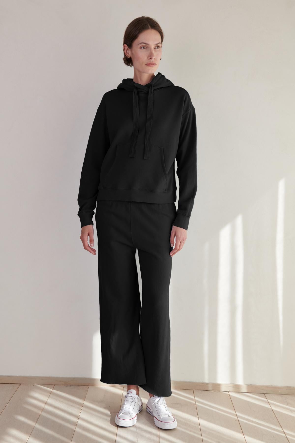 A woman wearing an OJAI HOODIE by Velvet by Jenny Graham and sweatpants.-26861801865409