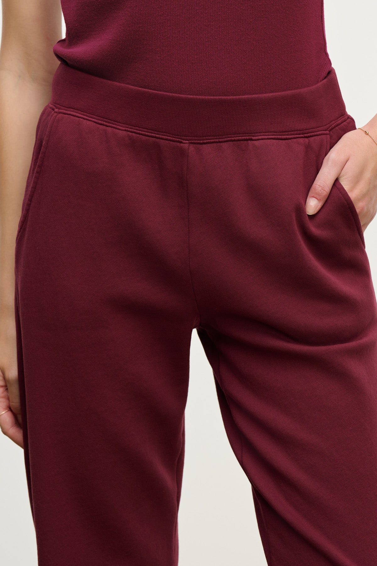 Person wearing relaxed fit burgundy ZARA SWEATPANT by Velvet by Graham & Spencer and a matching top, with one hand in the pocket.