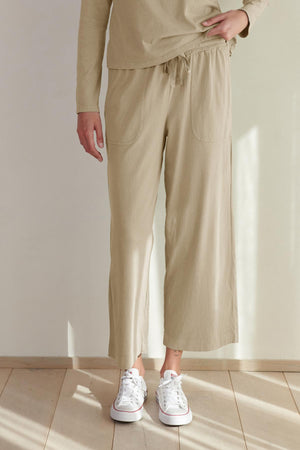 A person standing in a room wearing Velvet by Jenny Graham's PISMO PANT and white sneakers.