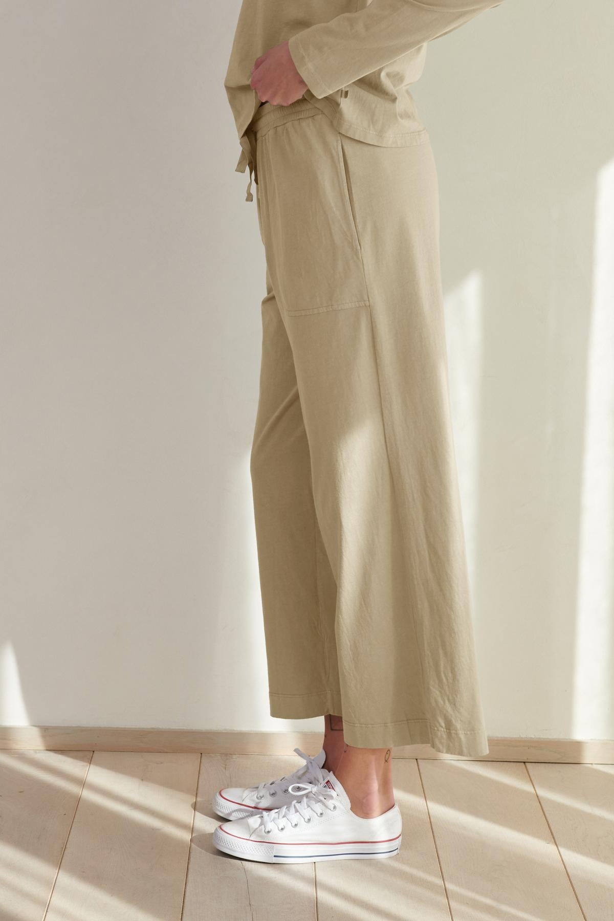 Person wearing Velvet by Jenny Graham PISMO PANT straight-leg pants and white sneakers standing in a room with natural light.-36463776530625