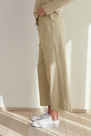 Person wearing Velvet by Jenny Graham PISMO PANT straight-leg pants and white sneakers standing in a room with natural light.