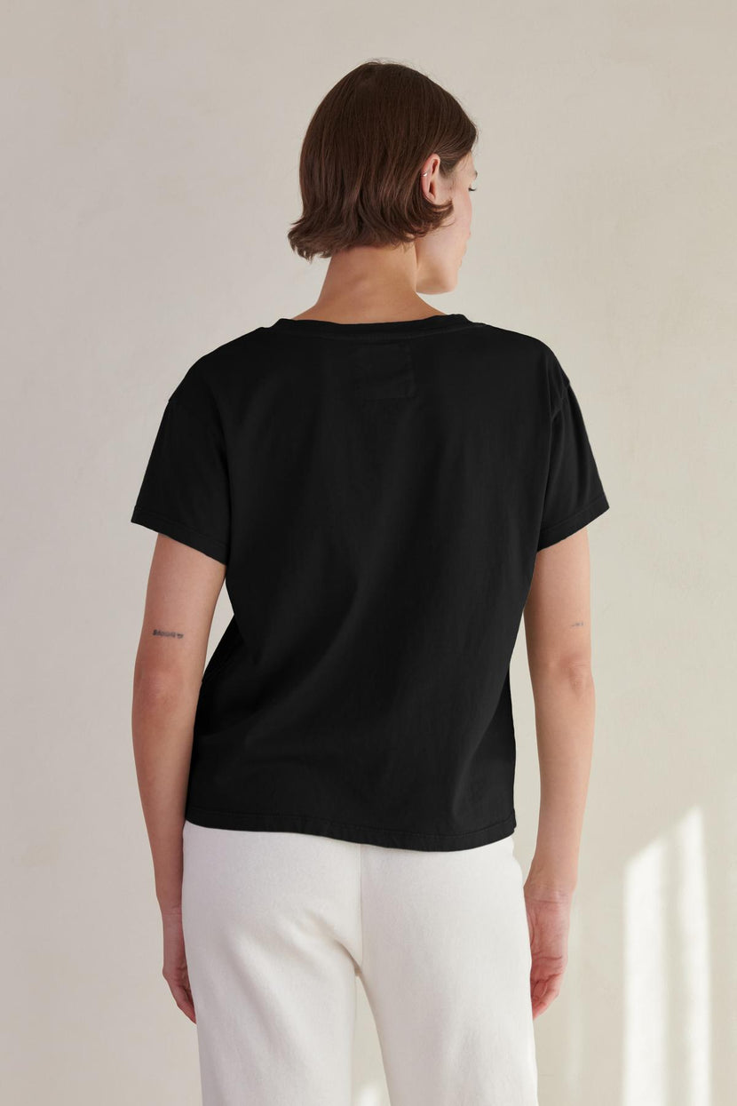 The back view of a woman wearing a Velvet by Jenny Graham VENICE TEE and white pants.