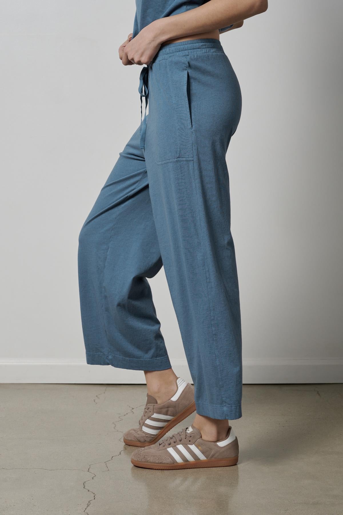   A woman wearing blue PISMO PANT made of organic cotton and Velvet by Jenny Graham sneakers. 