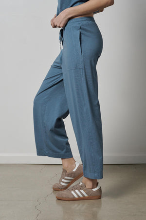 A woman wearing blue PISMO PANT made of organic cotton and Velvet by Jenny Graham sneakers.