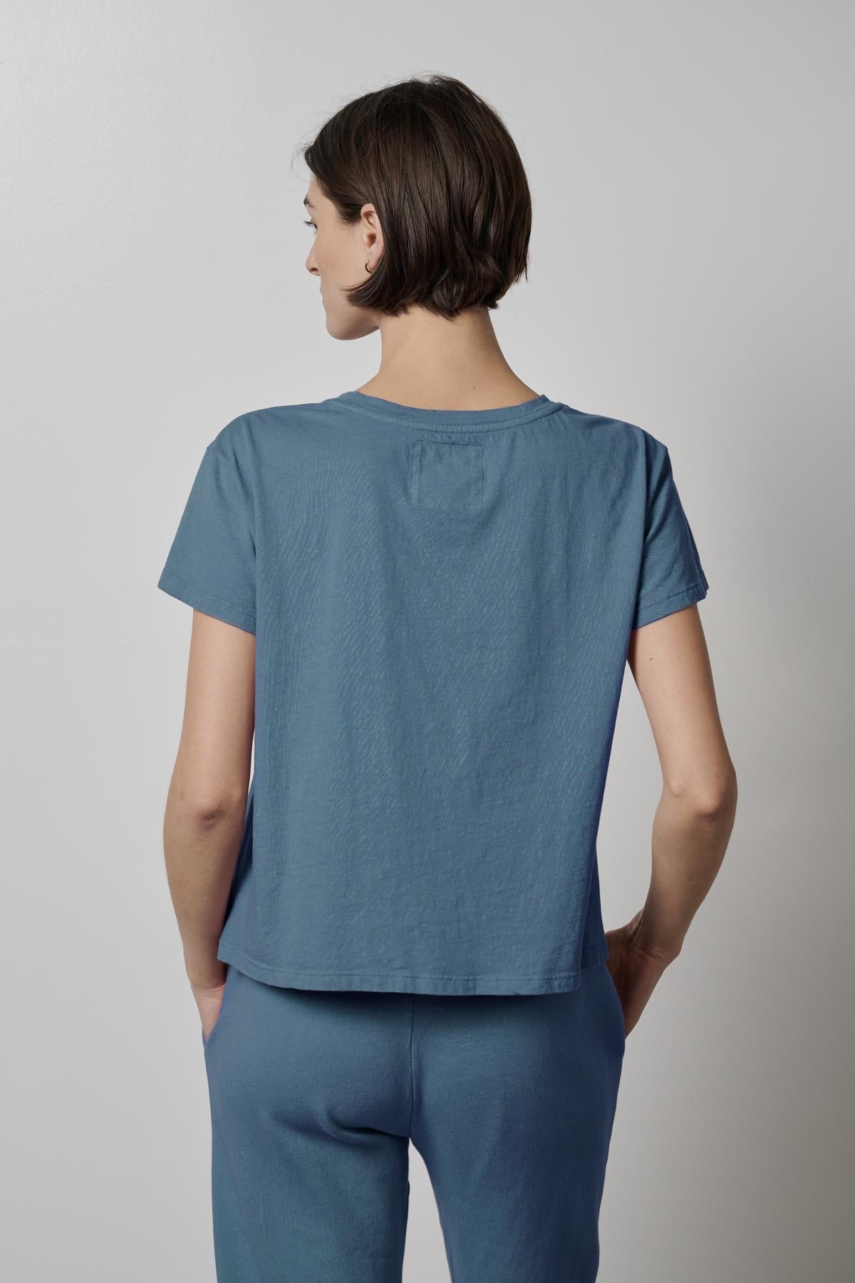 The back view of a woman wearing a blue Velvet by Jenny Graham TOPANGA TEE and pants.-35721216884929