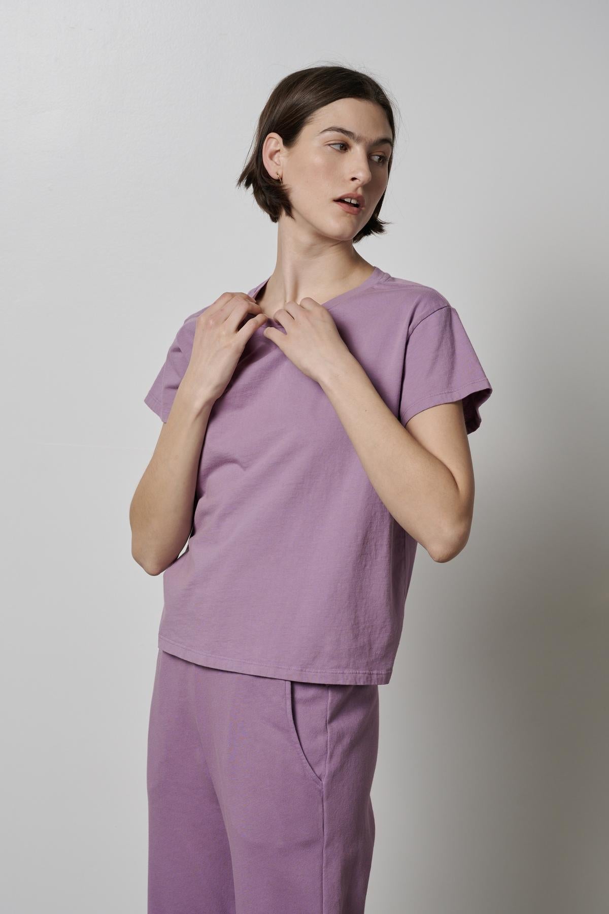   The model is wearing a purple Velvet by Jenny Graham TOPANGA TEE and pants. 