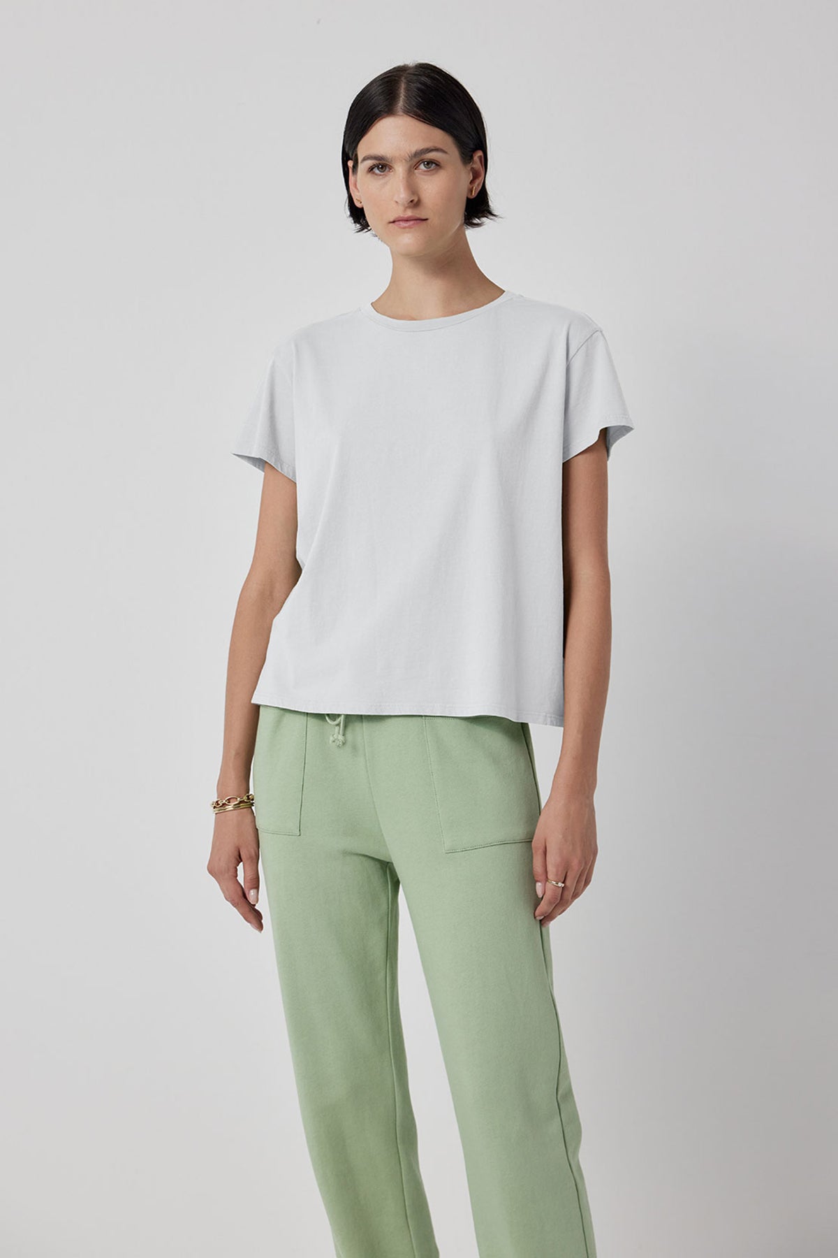 The model is wearing a TOPANGA TEE white t-shirt and Velvet by Jenny Graham organic cotton green trousers.-36212410548417