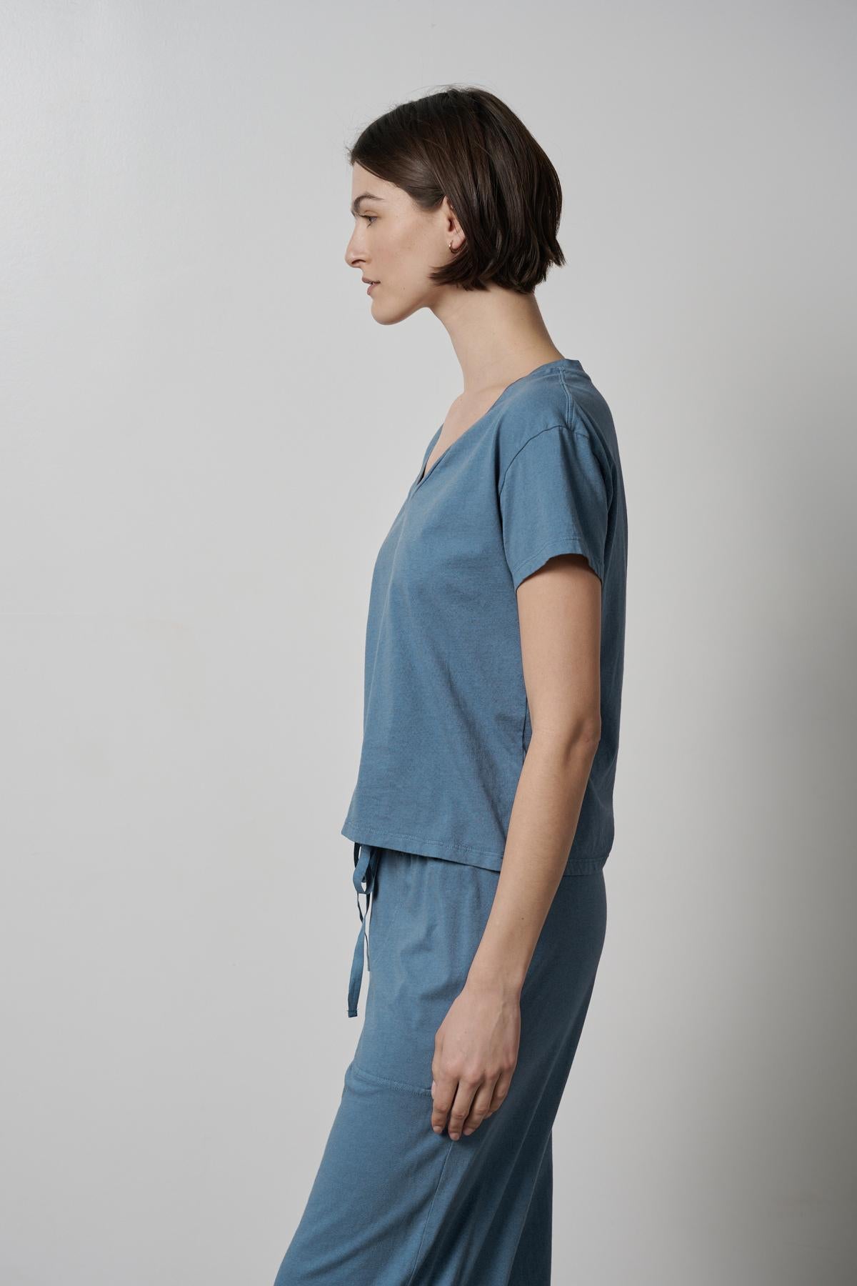 The model is wearing a blue Velvet by Jenny Graham organic cotton pyjama set.-35495940915393