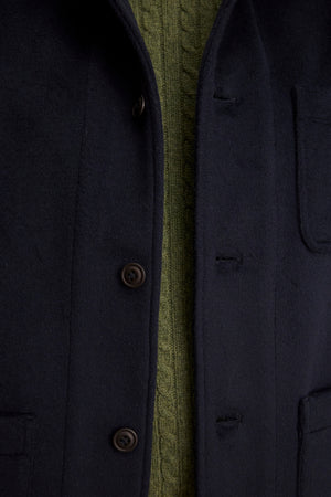 Close-up of the EMERSON CHORE JACKET by Velvet by Graham & Spencer, a black wool blend style, buttoned and layered over a green cable-knit sweater—ideal for everyday wear.