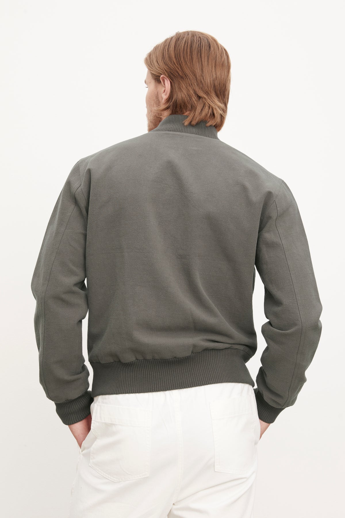 The back of a man wearing a Velvet by Graham & Spencer Garner Linen Blend Bomber Jacket and white pants.-36009937076417