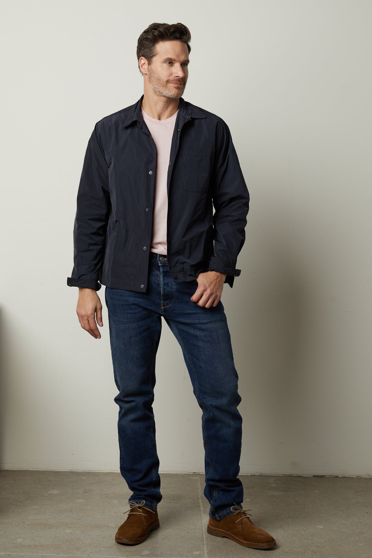   A man is standing in a room wearing jeans and a Velvet by Graham & Spencer JONES JACKET. 