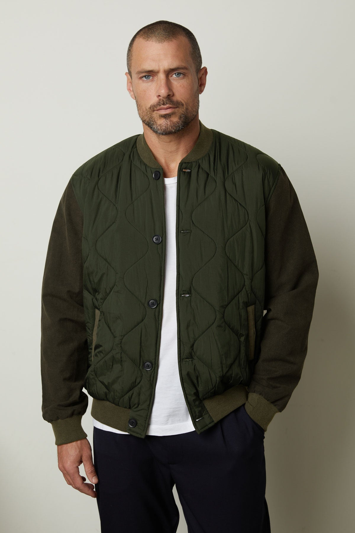   A man wearing a MAISON quilted jacket by Velvet by Graham & Spencer that combines functionality and style. 