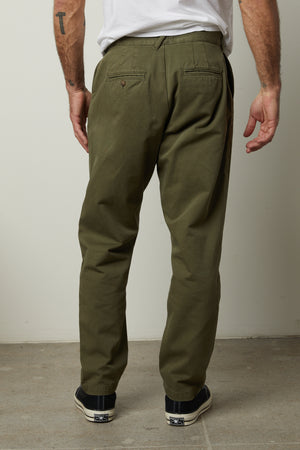 The back view of a man wearing Velvet by Graham & Spencer VINNY COTTON CANVAS PANT, straight-fit leg, olive green pants with 5 pocket styling.