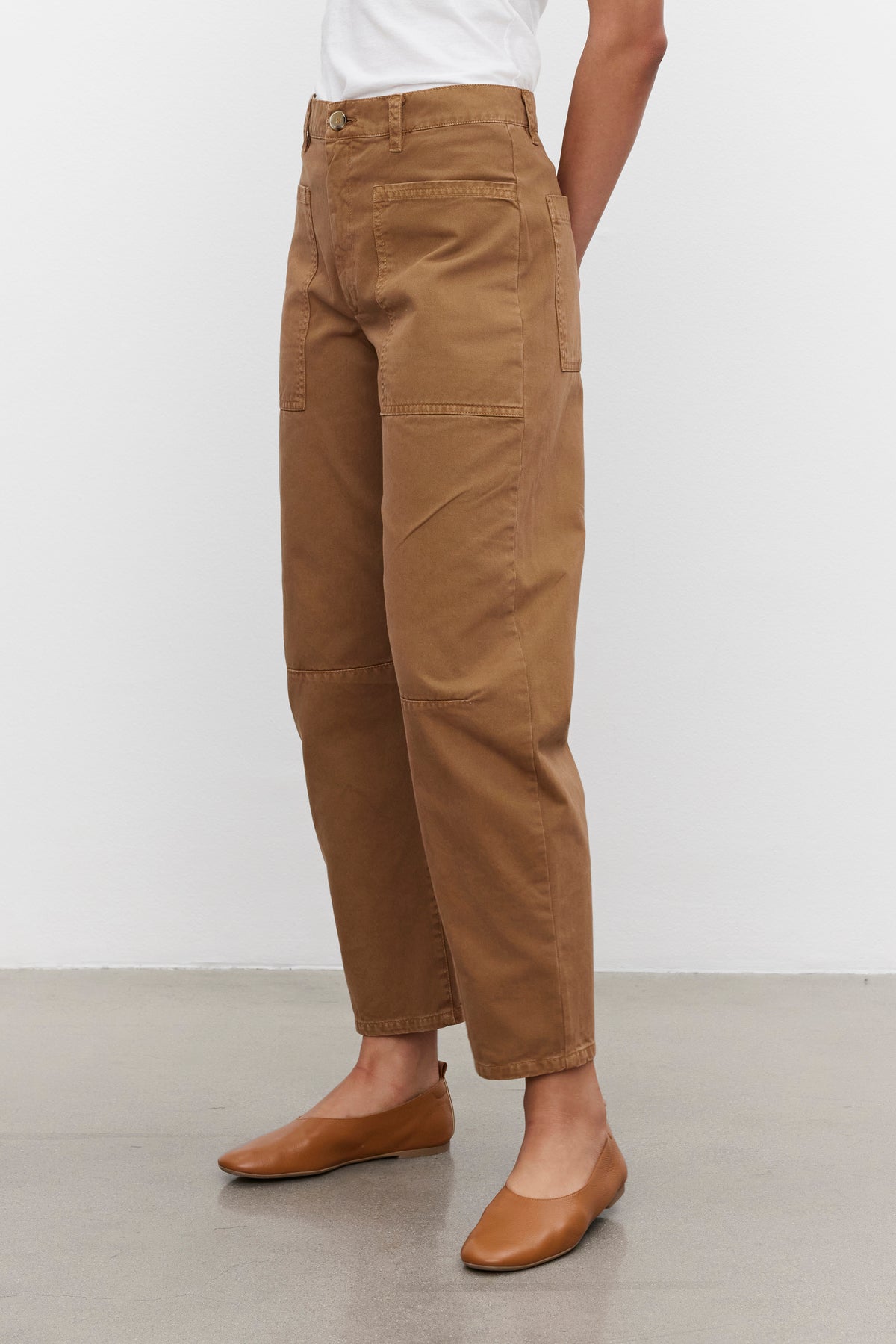   Person wearing BRYLIE SANDED TWILL UTILITY PANTS by Velvet by Graham & Spencer and a white shirt, standing on a gray floor. 