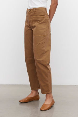 Person wearing BRYLIE SANDED TWILL UTILITY PANTS by Velvet by Graham & Spencer and a white shirt, standing on a gray floor.