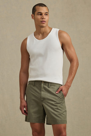 A man in a white sleeveless tank top and JOEL SHORT from Velvet by Graham & Spencer, featuring cotton twill fabric and 5-pocket styling, stands with one hand in his pocket against a neutral background.