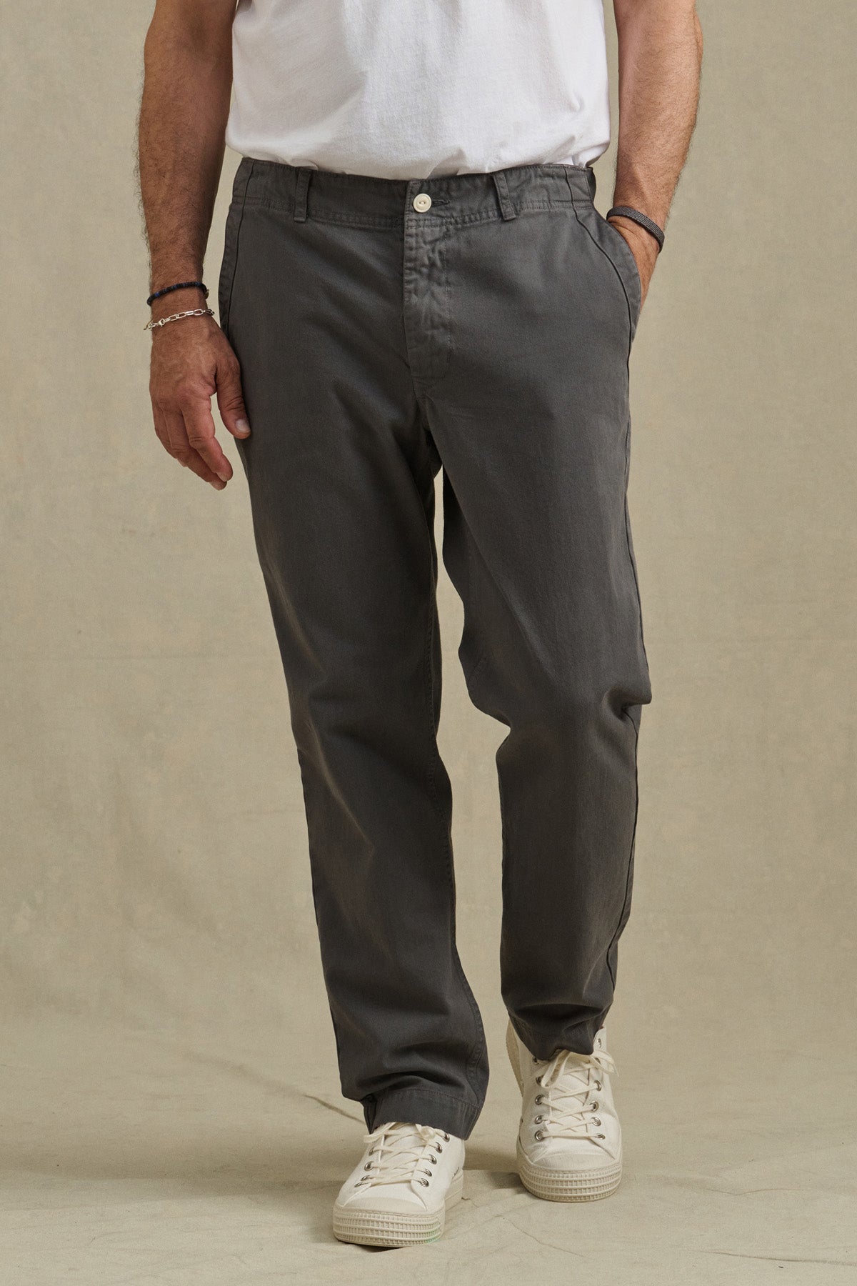 A person wears the LENNOX PANT by Velvet by Graham & Spencer, paired with a white t-shirt and white sneakers, standing hands in pockets against a plain background—an ideal look for everyday wear.-40850767413441