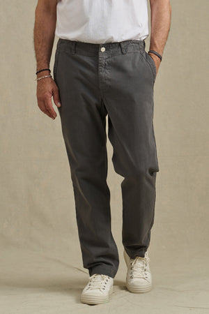 A person wears the LENNOX PANT by Velvet by Graham & Spencer, paired with a white t-shirt and white sneakers, standing hands in pockets against a plain background—an ideal look for everyday wear.