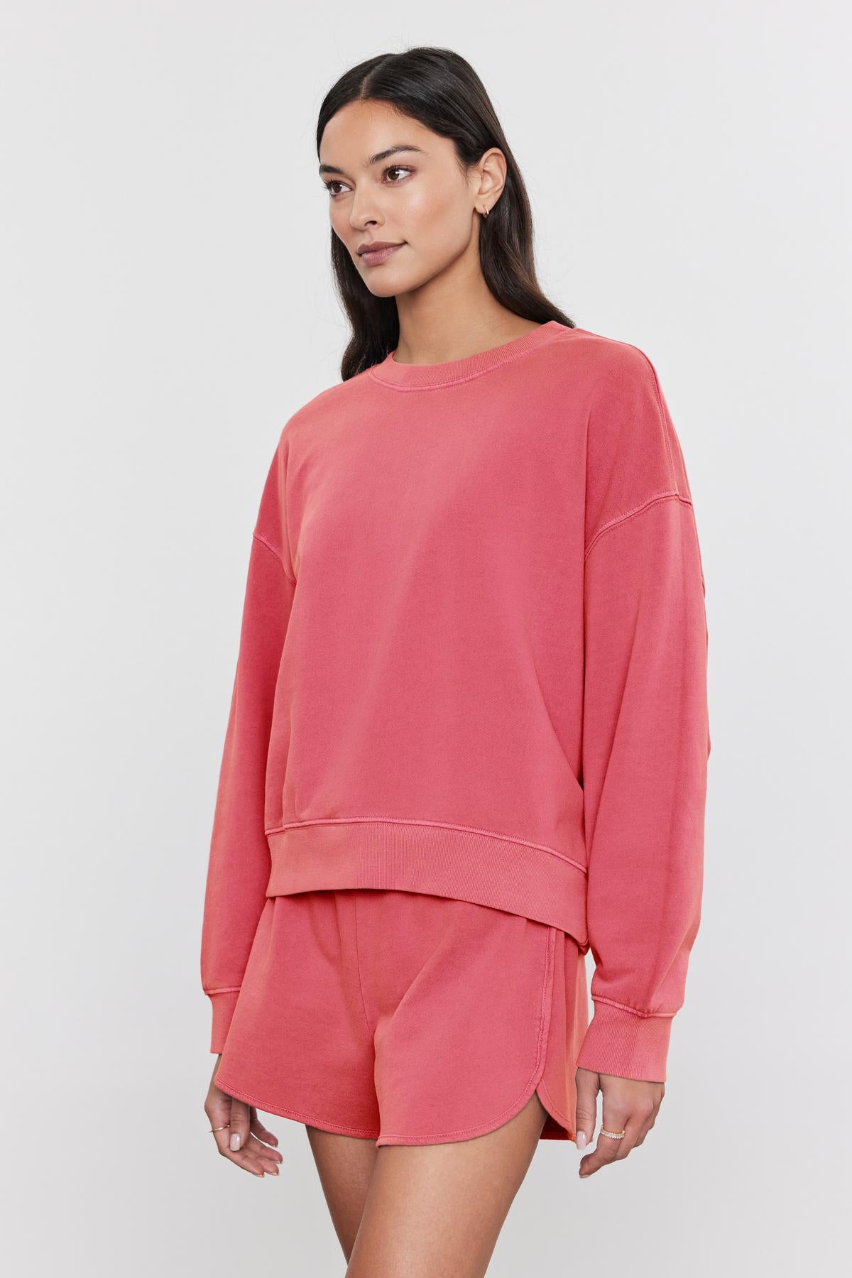   Woman standing in a studio wearing a relaxed fit, coral pink Velvet by Graham & Spencer 