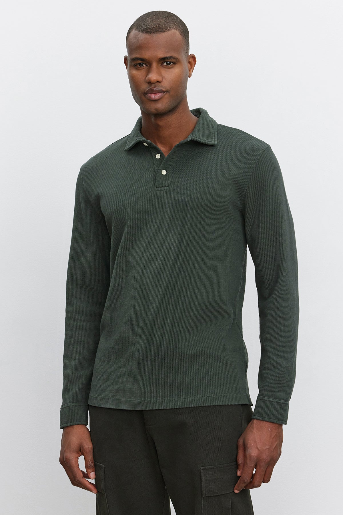   A man wearing a Velvet by Graham & Spencer MIKE POLO, a forest green long-sleeve shirt made of piqué cotton, stands against a plain white background. 