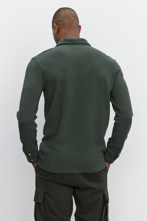 A person is shown from the back, wearing the MIKE POLO by Velvet by Graham & Spencer, a dark green long-sleeve polo made of piqué cotton, paired with matching dark green pants.