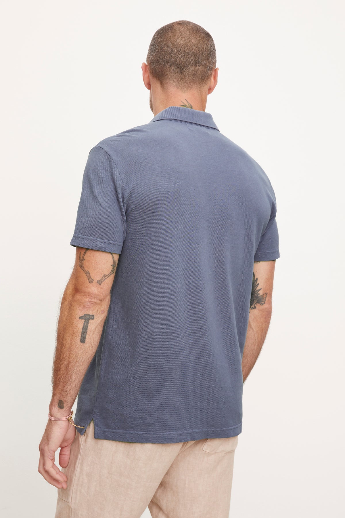   The back view of a man wearing a Velvet by Graham & Spencer Willis Pique Polo shirt. 