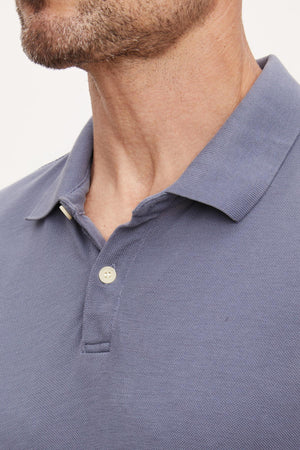 A man wearing a Velvet by Graham & Spencer WILLIS PIQUE POLO shirt.
