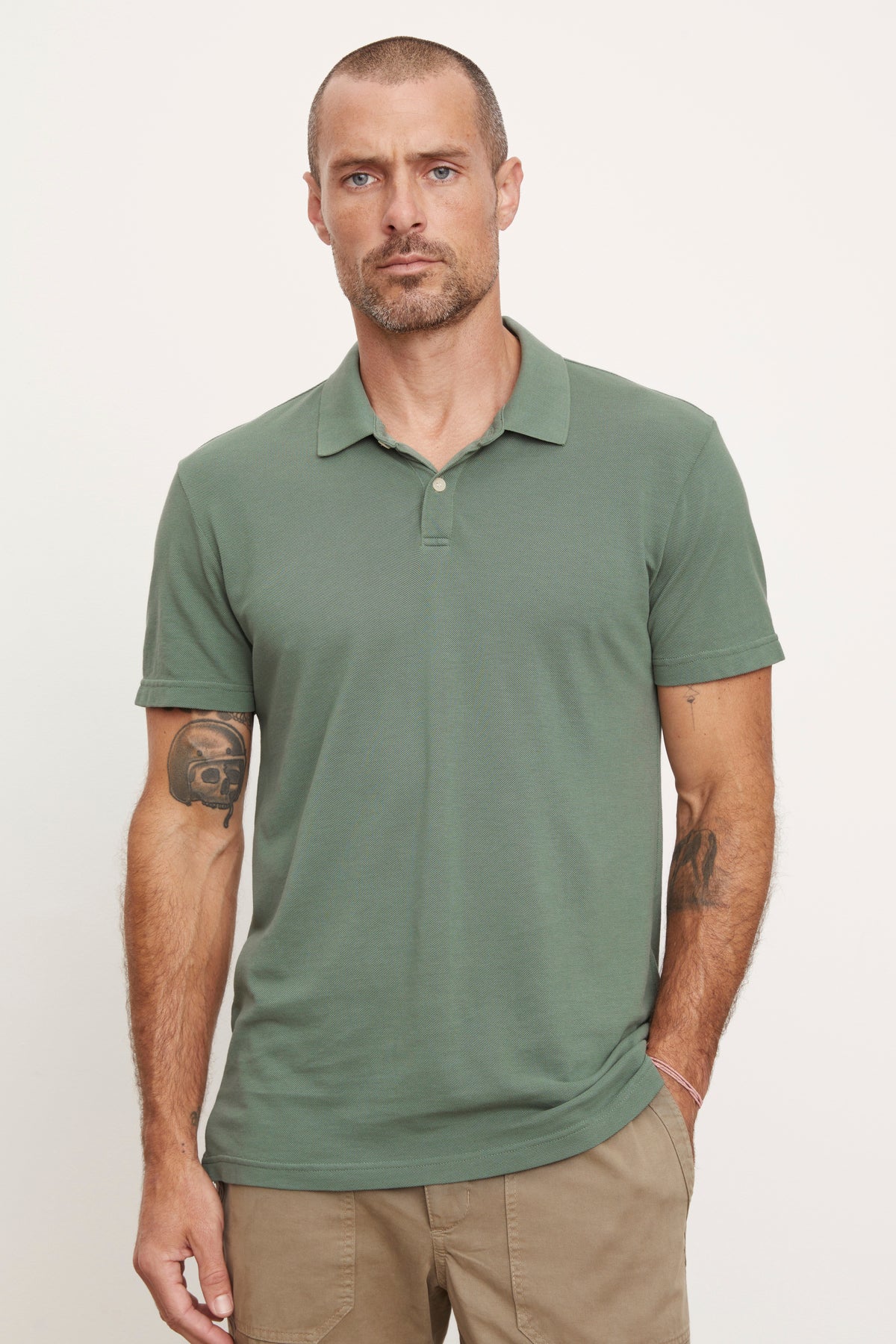   A man wearing a green Velvet by Graham & Spencer Willis Pique Polo shirt and khaki pants. 