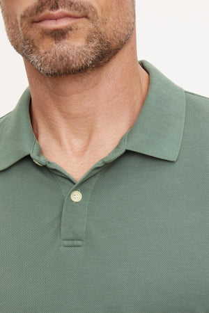 A man wearing a Velvet by Graham & Spencer Willis Pique Polo shirt.