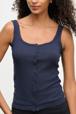 A woman wears the ADELLE TANK TOP by Velvet by Graham & Spencer—a sleeveless, navy blue, ribbed fitted top featuring a square neckline and button-front detail.