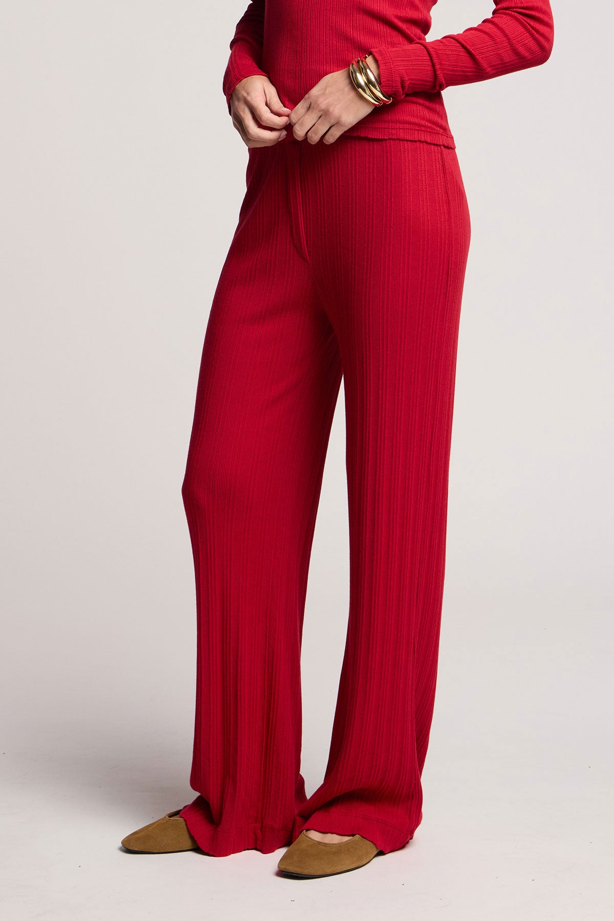 Someone wearing Velvet by Graham & Spencer's ALEMI POINTELLE PANT in red with a matching long-sleeve top, brown pointed-toe flats, and a gold bracelet, standing against a plain background.-40416877772993